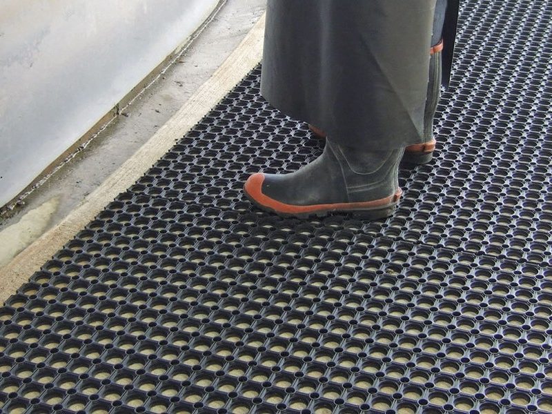 dairy farmer standing on surefoot mat at cups on station