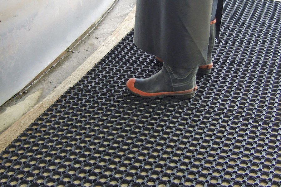 dairy farmer standing on surefoot mat at cups on station